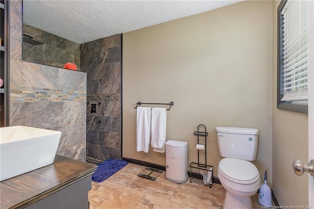 bathroom featuring tiled shower, sink, a textured ceiling, and toilet