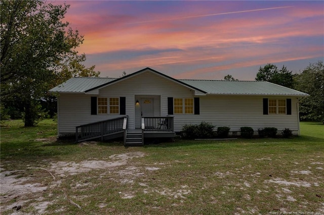 view of front of house with metal roof and a front lawn