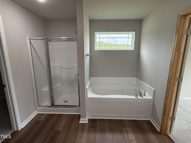 bathroom with independent shower and bath and hardwood / wood-style floors