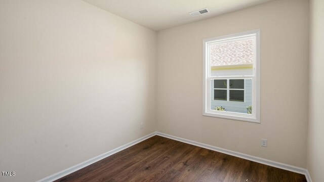 unfurnished room with dark wood-type flooring