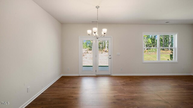 interior space featuring an inviting chandelier, dark hardwood / wood-style floors, and plenty of natural light