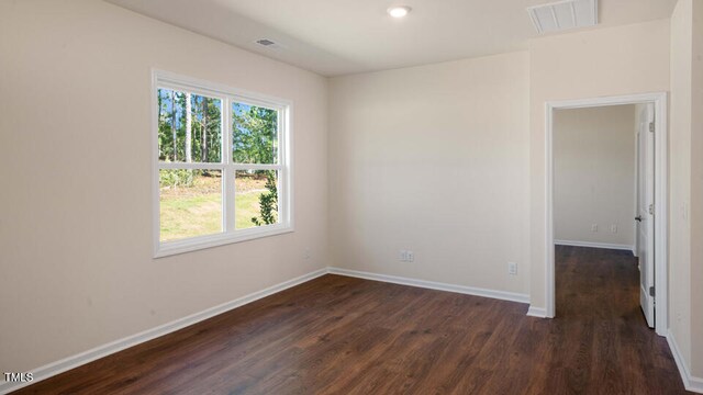 unfurnished room with dark hardwood / wood-style flooring