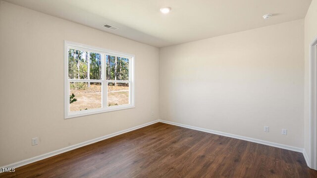 unfurnished room with dark wood-type flooring