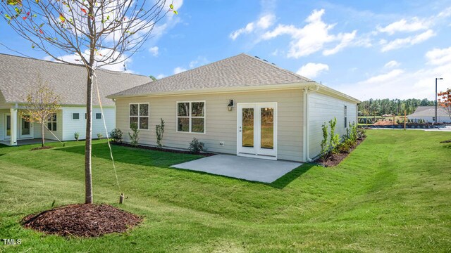 back of house with a lawn and a patio