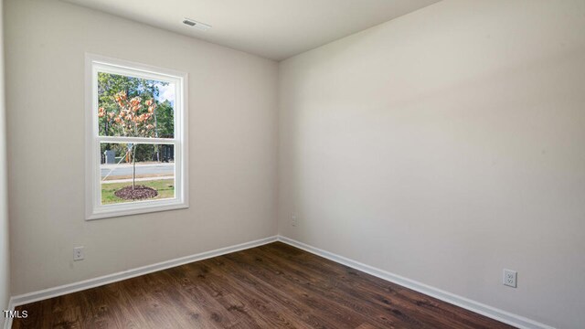 spare room featuring dark wood-type flooring