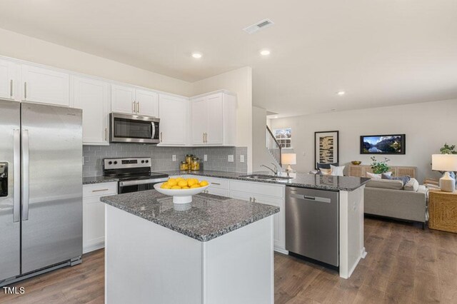 kitchen with a kitchen island, dark hardwood / wood-style floors, appliances with stainless steel finishes, and white cabinets