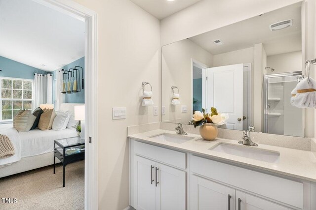 bathroom with vaulted ceiling, a shower with door, and vanity