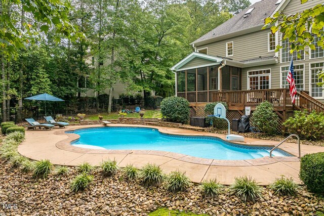 view of swimming pool with a patio, a diving board, a deck, and a sunroom