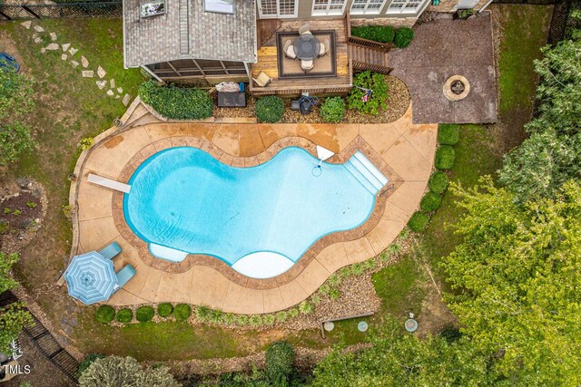 view of swimming pool with a patio and a diving board