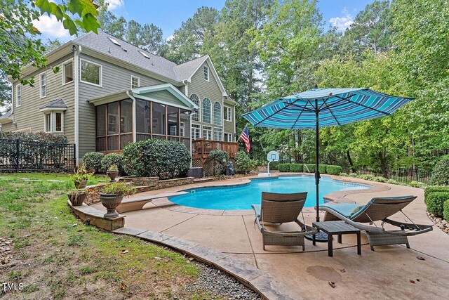 view of pool with a sunroom and a patio