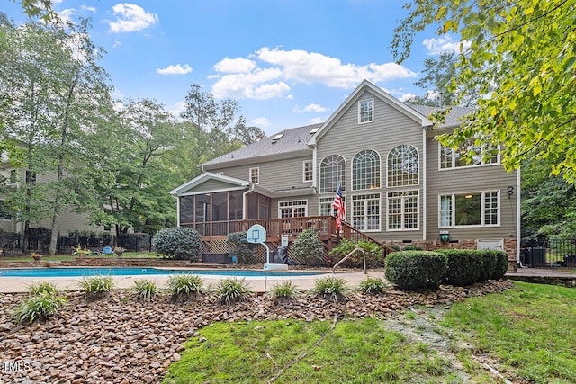 back of property with a pool side deck and a sunroom