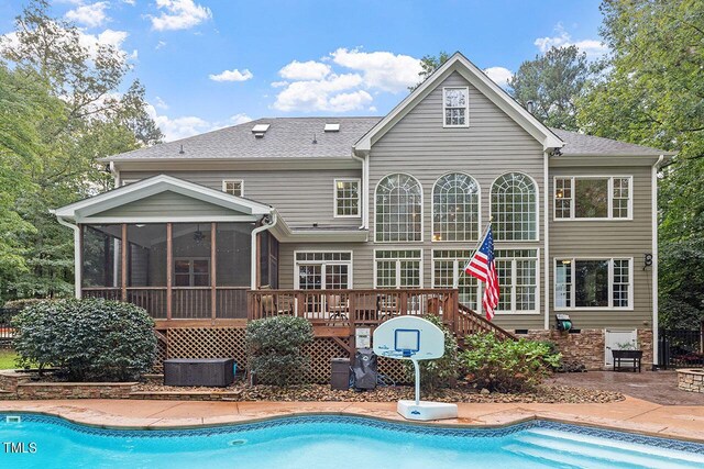 back of property featuring a pool side deck, a sunroom, and a patio area