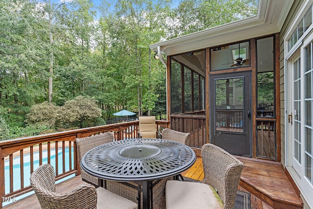 wooden deck with ceiling fan and a sunroom