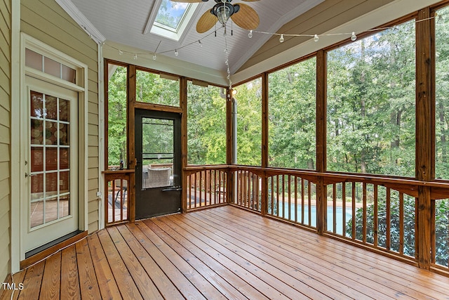 unfurnished sunroom with vaulted ceiling with skylight and ceiling fan