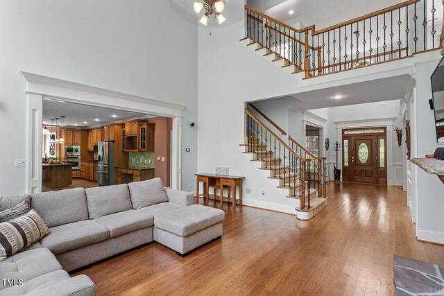 living room with light hardwood / wood-style floors and a high ceiling