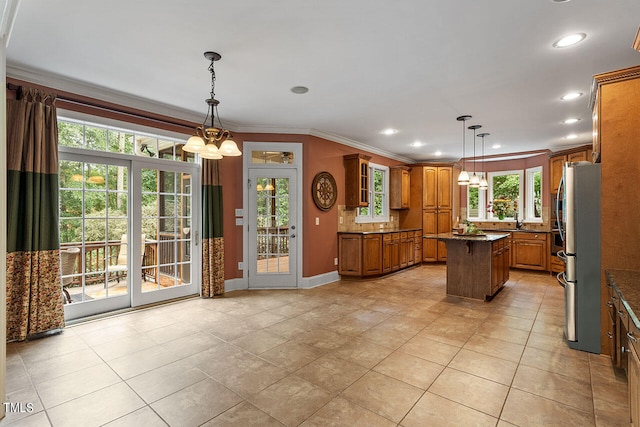 kitchen with stainless steel fridge, decorative light fixtures, a center island, a notable chandelier, and crown molding