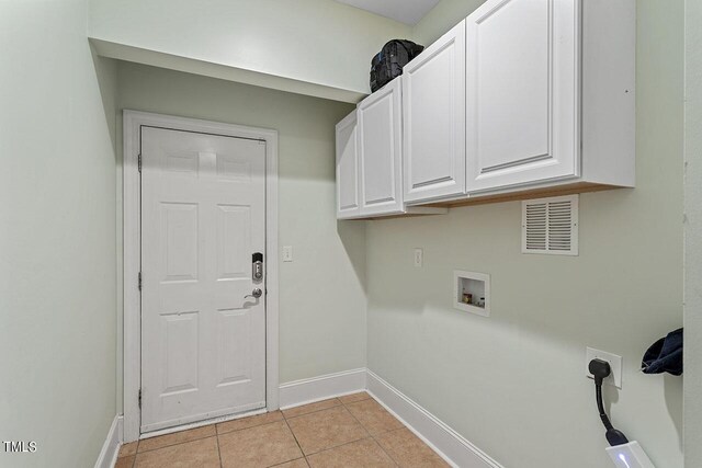 washroom with washer hookup, hookup for an electric dryer, cabinets, and light tile patterned floors