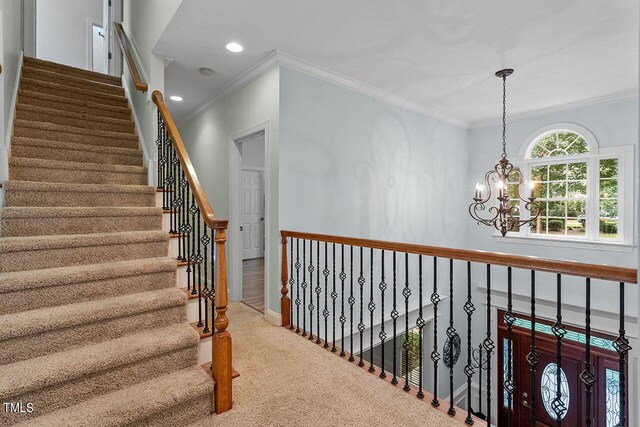 interior space featuring crown molding, carpet flooring, and a notable chandelier