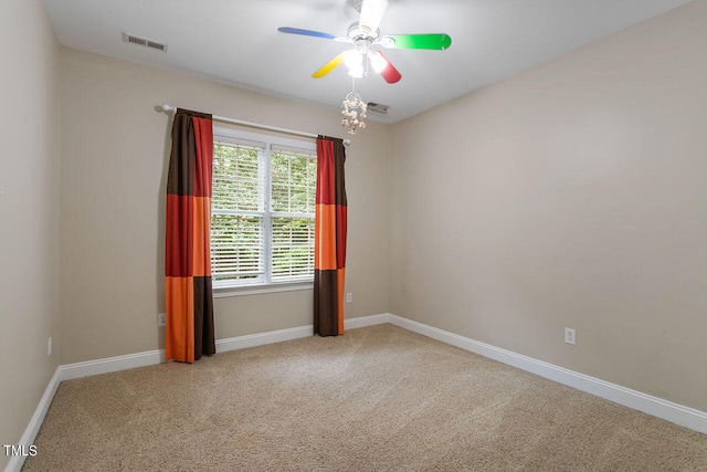 empty room featuring light colored carpet and ceiling fan with notable chandelier