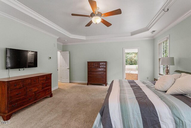 carpeted bedroom featuring ceiling fan, ensuite bathroom, a raised ceiling, and ornamental molding