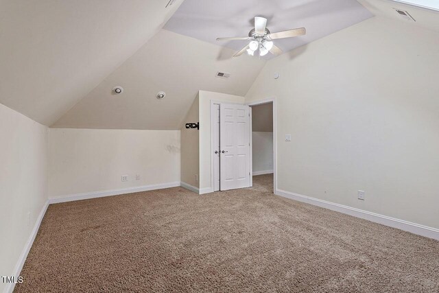 additional living space featuring carpet floors, lofted ceiling, and ceiling fan