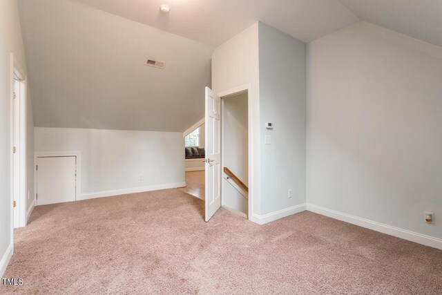 additional living space featuring light carpet and lofted ceiling