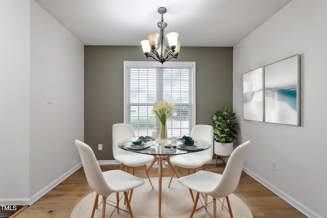 dining area with hardwood / wood-style flooring and a notable chandelier