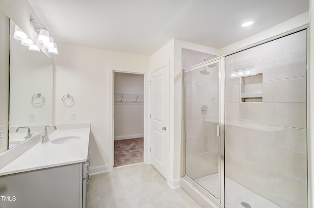 bathroom featuring tile patterned flooring, walk in shower, and vanity