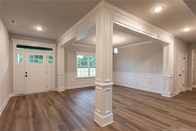 entrance foyer featuring decorative columns, dark hardwood / wood-style floors, and ornamental molding