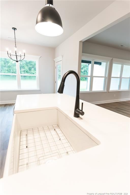 interior details featuring a chandelier, hardwood / wood-style floors, pendant lighting, and sink