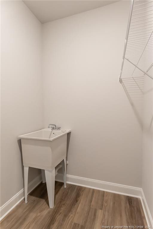 washroom with dark hardwood / wood-style floors and sink