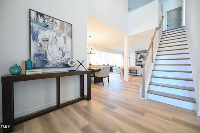 foyer featuring a high ceiling, an inviting chandelier, and light hardwood / wood-style flooring