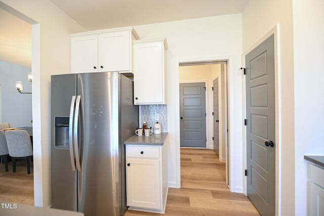 kitchen featuring white cabinetry, stainless steel fridge with ice dispenser, tasteful backsplash, and light hardwood / wood-style floors