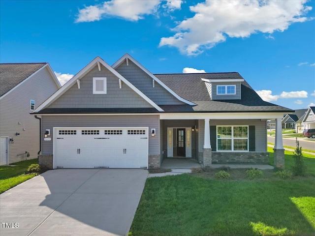 craftsman-style home featuring a porch, a garage, and a front yard