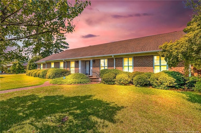 ranch-style home with a yard