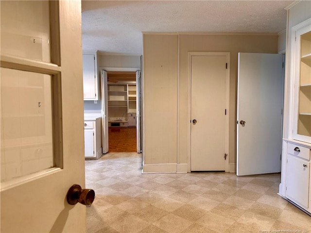 interior space featuring a textured ceiling and ornamental molding