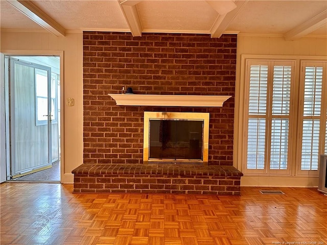 unfurnished living room featuring a wealth of natural light, a fireplace, beam ceiling, and a textured ceiling