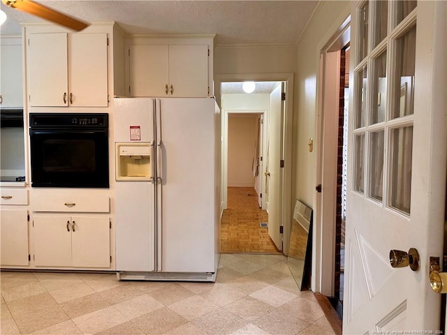 kitchen featuring white cabinets, black oven, white refrigerator with ice dispenser, and a textured ceiling