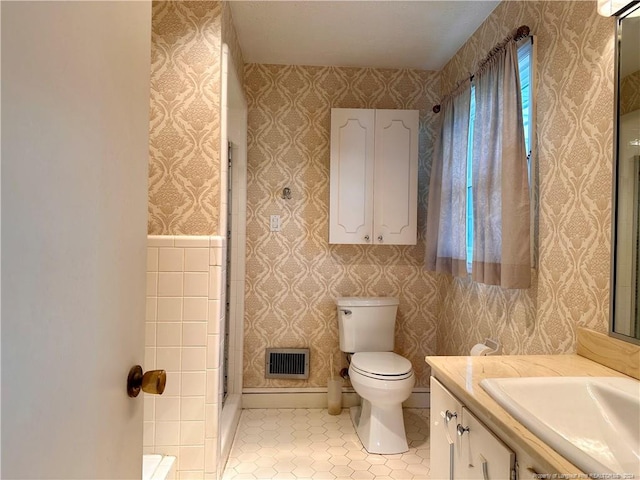 bathroom featuring a shower with door, vanity, and toilet