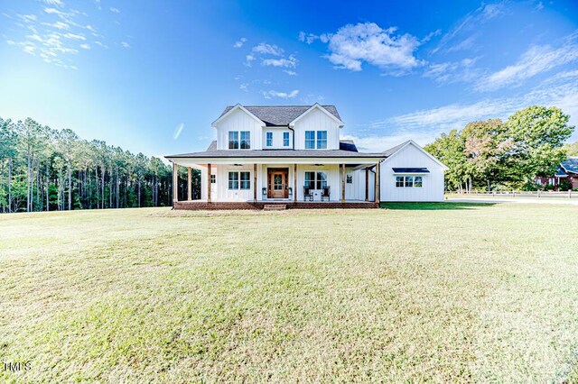 modern inspired farmhouse featuring a front yard, a porch, and board and batten siding
