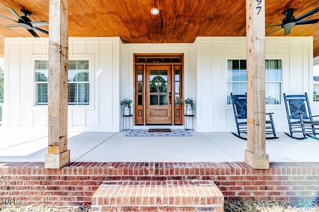 property entrance featuring a porch, ceiling fan, and board and batten siding