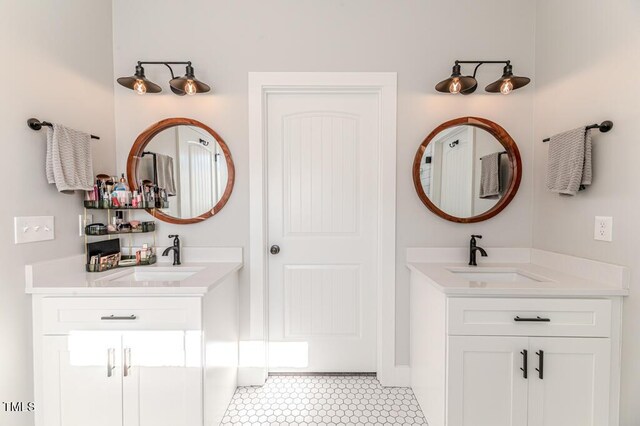 full bath featuring a sink and two vanities
