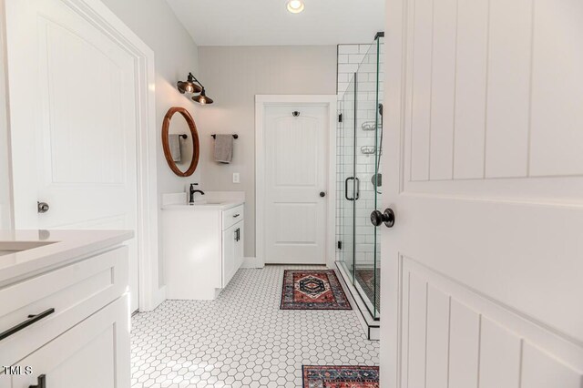 full bathroom with a sink, a stall shower, recessed lighting, and two vanities