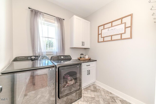 laundry area with baseboards, washer and dryer, and cabinet space