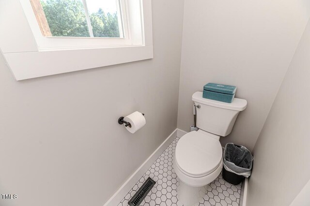 bathroom featuring tile patterned floors, visible vents, toilet, and baseboards