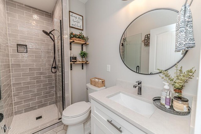 full bath with vanity, toilet, tile patterned floors, and a shower stall