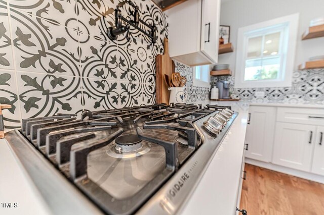 kitchen with light wood-style floors, white cabinetry, open shelves, and backsplash