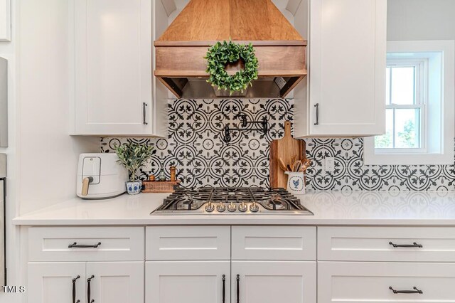 kitchen with white cabinetry, light countertops, decorative backsplash, stainless steel gas stovetop, and custom exhaust hood