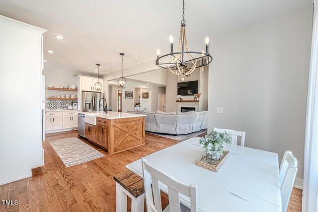 dining area featuring light wood-style floors, recessed lighting, and a chandelier