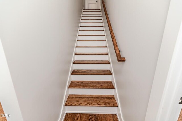 stairway featuring baseboards and wood finished floors